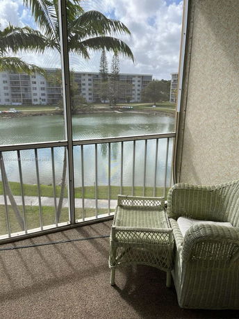 View from a balcony looking out at a lake and apartment buildings across the water.