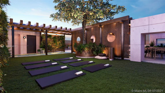 Rooftop area with yoga mats, greenery, and wooden structures.