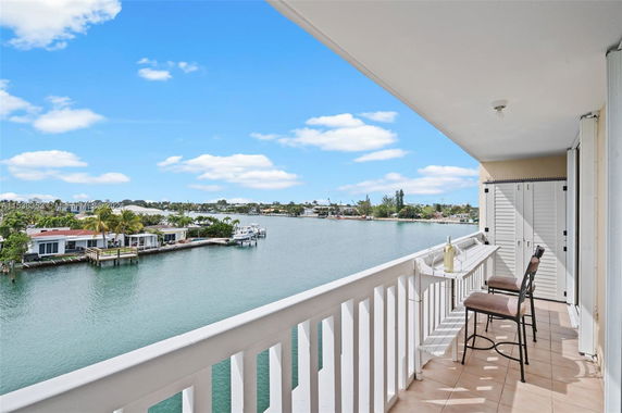 Panoramic view from a balcony overlooking a waterfront and houses.