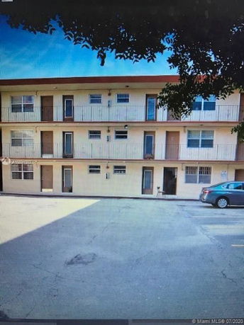 Front view of a three-story apartment building with balconies.