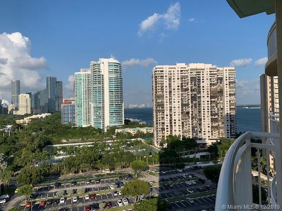 View of high-rise buildings and water body seen from a balcony.