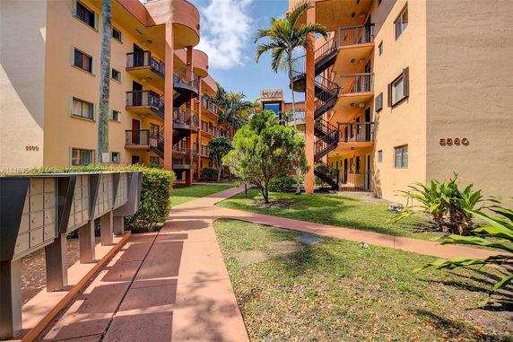 Front view of a multi-story apartment building with balconies and external staircases.