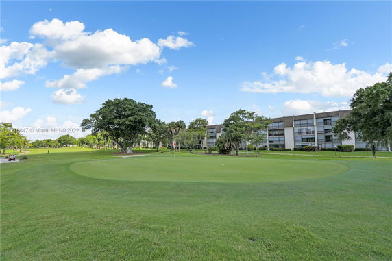 View of a low-rise building with a golf course in the foreground.