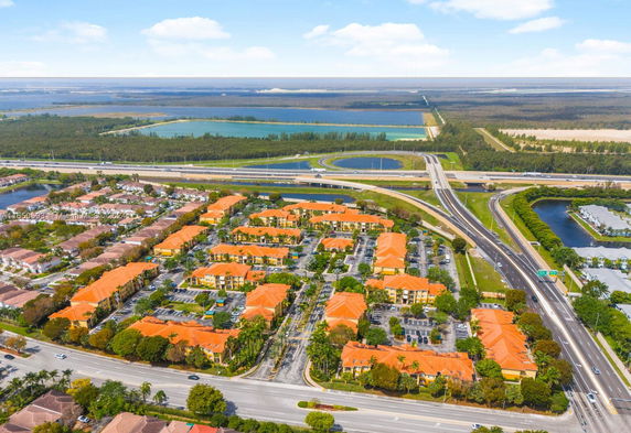 Aerial view of a residential area with multiple buildings and nearby highway.