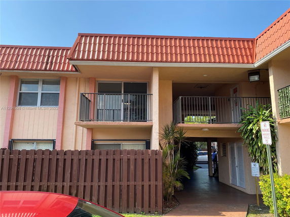 Front view of a two-story building with a red tile roof and balcony.
