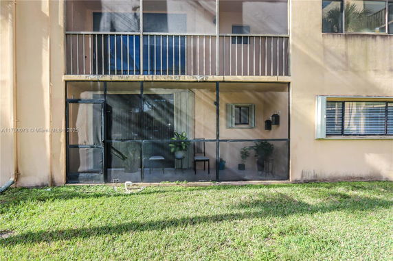 Front view of a building with a screened patio and balcony.