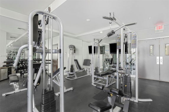 Interior view of a gym with various exercise machines and weights.
