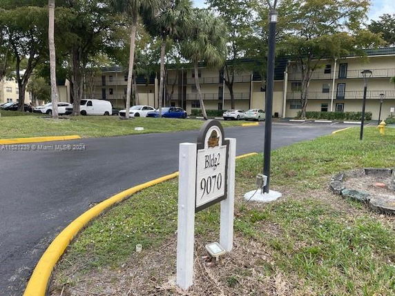 Front view of a multi-story residential building with a parking area.