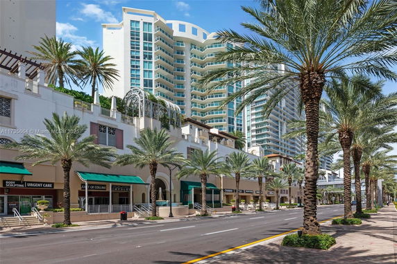 Front view of a multi-story building with shops at the ground level.