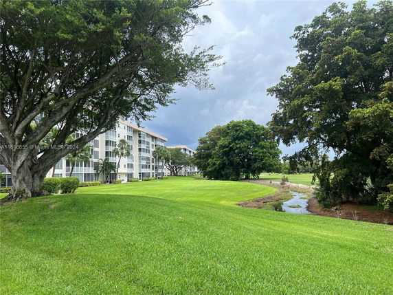 View of a multi-story building in a green landscaped area.