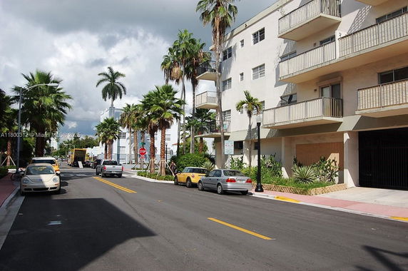 Street view featuring a multi-story building with balconies.