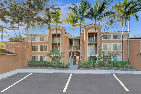 Front view of a multi-story building with balconies and a central entrance.