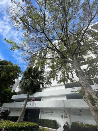 Front view of a multi-story apartment building with a white facade.