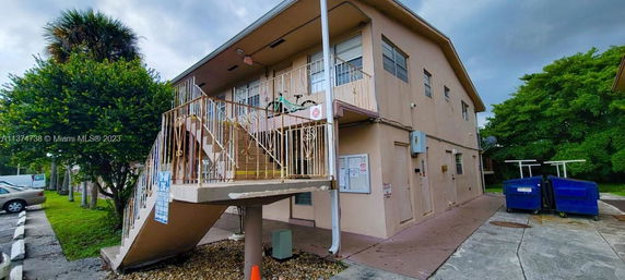 Front view of a two-story residential building with an external staircase.