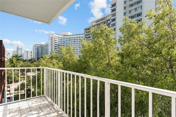 View from a balcony overlooking high-rise buildings and trees.