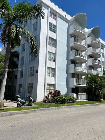 Front view of a multi-story apartment building with balconies.
