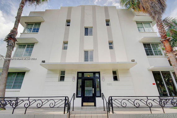 Front view of a multi-story building with large windows and decorative facade.