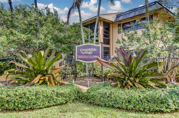 Front view of a two-story condominium building with a prominent entrance sign.