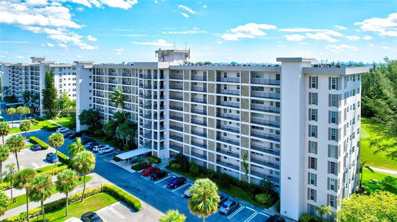 Front view of a multi-story apartment building with parking area.