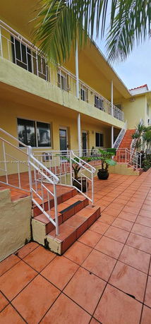 Front view of a two-story building with balconies and tiled flooring.