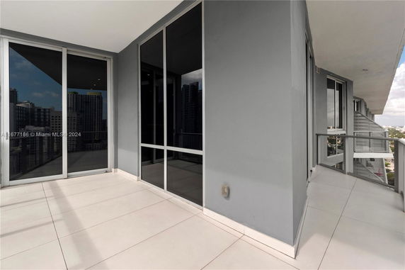 Balcony area of a high-rise building with glass railings overlooking the city skyline.