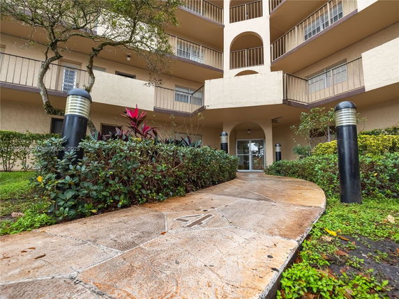 Front view of a multi-story residential building with balconies and entrance.