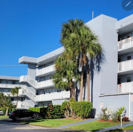 Front view of a multi-story apartment building with balconies and external staircases.