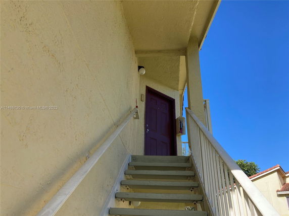 Stairway leading to the entrance of a building with a brown door.