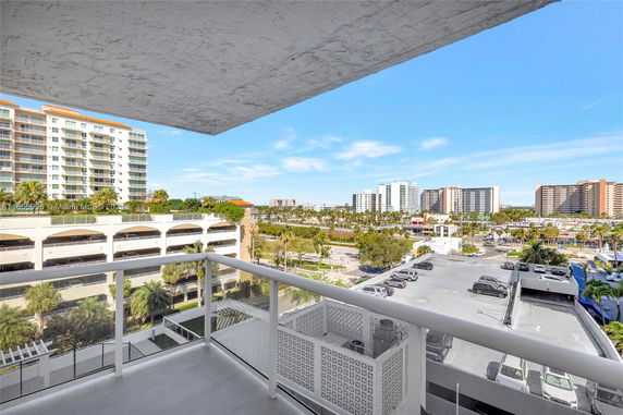 Balcony view overlooking buildings and parking areas.