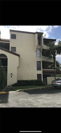 Front view of a multi-story building with a parking area.