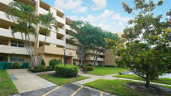 Front view of a multi-story building with balconies and entrance area.
