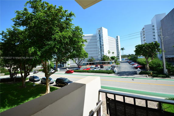 View of surrounding area with multiple multi-story buildings and a parking lot.