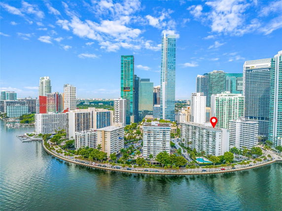 Aerial view of a cityscape with high-rise buildings along a waterfront.