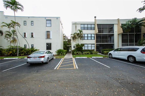 Outdoor parking area in front of a multi-story building.