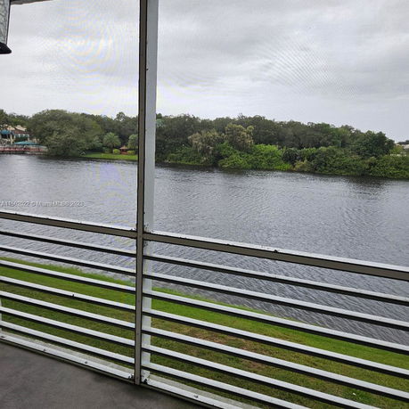 Panoramic view of a river with trees lining the opposite bank, seen from a patio or balcony.