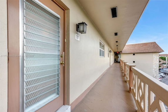 Corridor of a multi-story building with a view of the parking area.