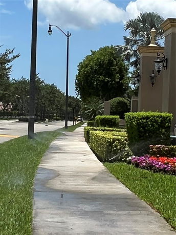 Sidewalk view with landscaping and street lamp.