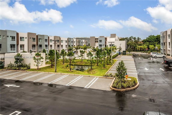 Outdoor parking area in front of a modern residential complex.