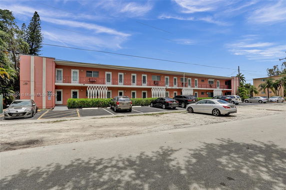 Front view of a two-story apartment building with parking area.