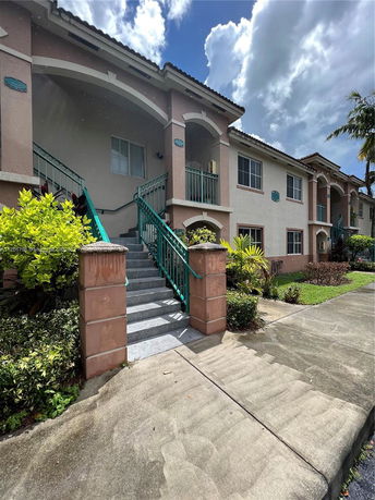 Front view of a two-story building with stairs leading up to the entrance.