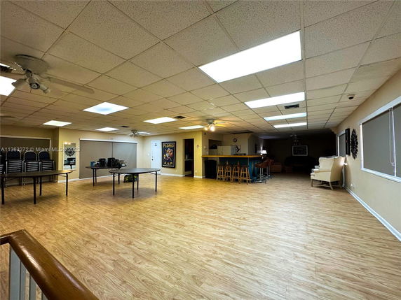 Large indoor communal area with tables, chairs, and a counter with bar stools.