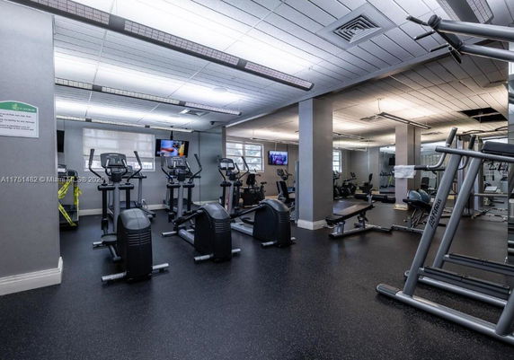 Interior view of a gym with exercise equipment and mirrors.