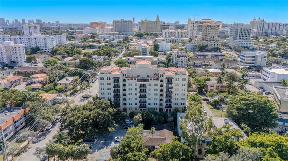 Aerial view of a cityscape with mid-rise buildings and greenery.
