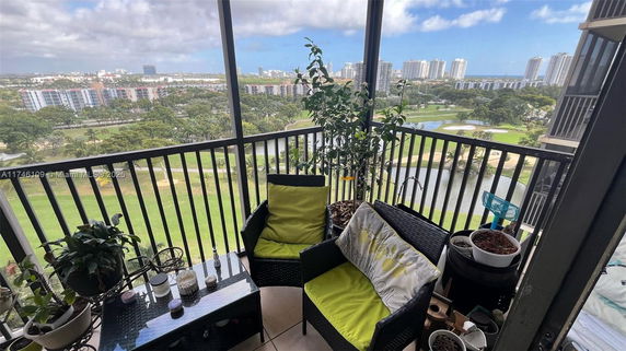 Panoramic view from a balcony overlooking a golf course and city skyline.