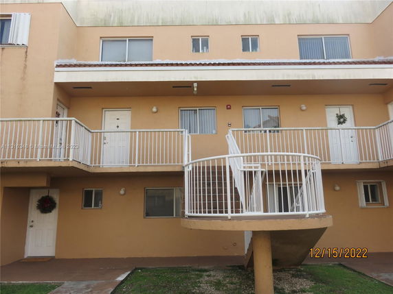 Front view of a multi-story building with balconies and external stairs.
