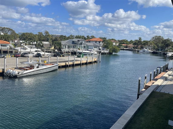 Waterfront view with docks and houses in the background.