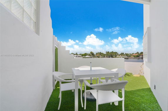 Open rooftop area with outdoor furniture and artificial grass.