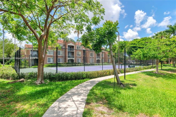 Tennis court with apartment building in the background.