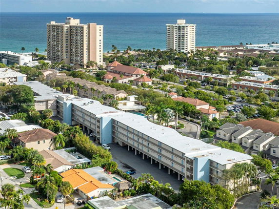 Aerial view of a coastal area with multiple multi-story residential buildings and the ocean in the background.