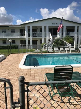 View of a two-story building with a swimming pool in the foreground.
